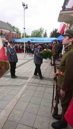 Policjanci składają wiązankę pod tablica Marszałka Piłsudskiego