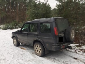 W lesie zaparkowany samochód terenowy koloru granatowego