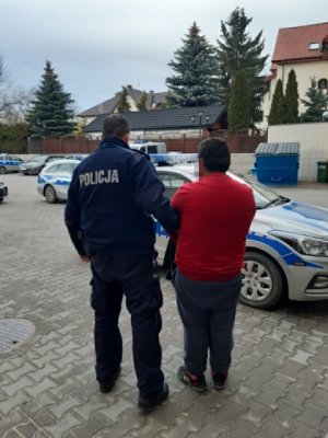 Umundurowany policjant z zatrzymanym mężczyzną