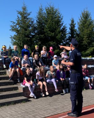 Umundurowany policjant z grupą uczniów