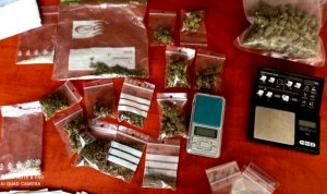 Na stole leżą opakowania z marihuaną i ekstazy. Jest też waga i telefon