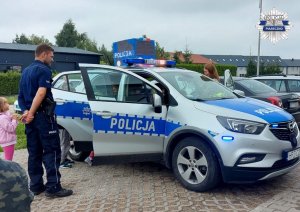 Policjant prezentuje radiowóz