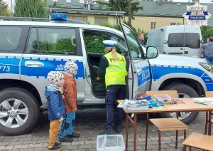 Policjantka przy radiowozie z dziećmi