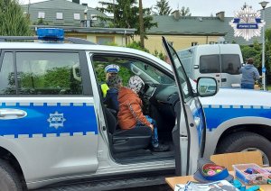 Dziecko w radiowozie a obok policjantka