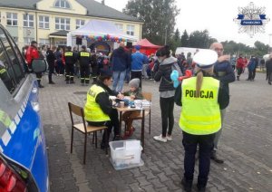 Dzieci przy stoliku kolorują rysunki policjanta