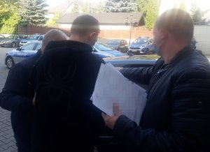 Nieumundurowani policjanci wraz z zatrzymanym mężczyzną wsiadają do samochodu