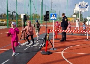 Uśmiechnięte dzieci ćwiczą zasady na drodze