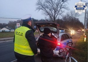 Policjanci prezentują rowerzyście magiczną tubę i widoczność na drodze z odblaskami