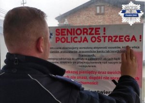 Policjanci w trakcie kolportażu plakatów ostrzegających przed oszustami