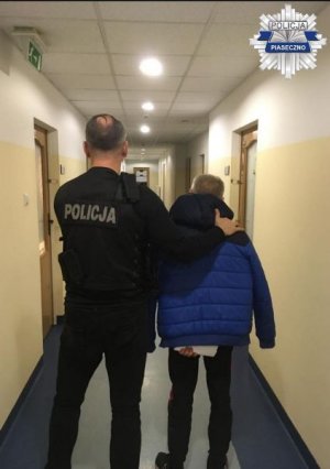 Policjant prowadzi zatrzymanego mężczyznę