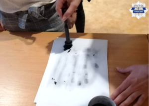 Policjantka przeprowadza pokaz daktyloskopii
