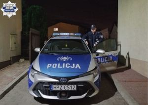 Policjant dzielnicowy przy radiowozie