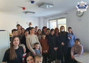 Zdjęcie policjantów wraz z uchodźcami w jednym z pokoi w internacie