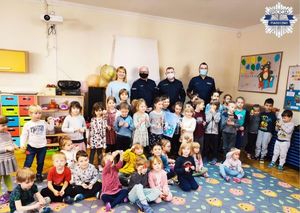 Zdjęcie grupowe przedszkolaków wraz z policjantami oraz dyrekcją w sali przedszkolnej