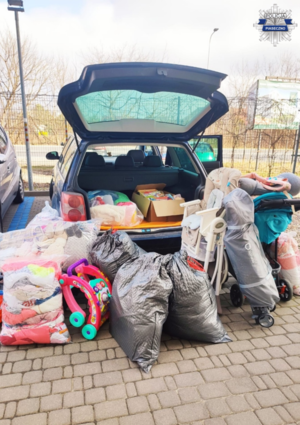 zebrane dary dla uchodźców - buty, ubrania, artykułu dla dzieci ustawione przed samochodem