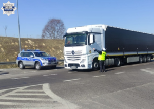 Policjanci kontrolują samochód ciężarowy, rozmawiają z kierowcą