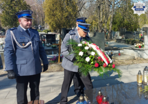 Delegacja policjantów składająca wiązankę kwiatów na grobie komisarza Mirosława Żaka