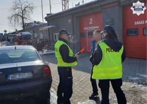 Policjanci stoją wraz z kontrolowanym mężczyzną i rozmawiają