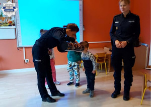 Policjantki za pomocą magicznej tuby prezentują dzieciom widoczność pieszych noszących odblaski, a także tych którzy tego nie robią