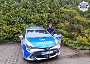 Policjant stoi przy radiowozie