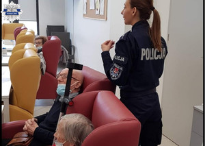 Policjanta na spotkaniu z seniorami. Seniorzy siedzą, policjantka stoi obok