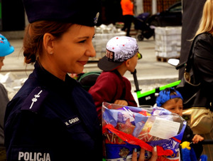 Policjantka czekająca ze słodkimi nagrodami na uczestników pikniku