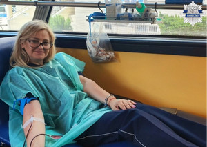 Policjantka siedząca na fotelu podczas pobierania krwi