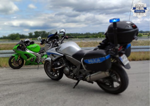 Motocykl policyjny a obok niego kontrolowany motocykl Kawasaki koloru zielonego