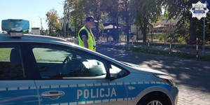 Policjant przed szkołą, obok radiowóz