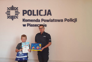 Chłopiec który zajął pierwsze miejsce odebrał nagrodę, zdjęcie z policjantką