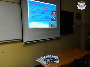 Zdjęcie prezentacji, na stoliku leżą broszury promujące pracę policji