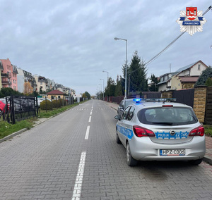 Jedna z ulic w Piasecznie, policyjny radiowóz z włączonymi sygnałami świetlnymi
