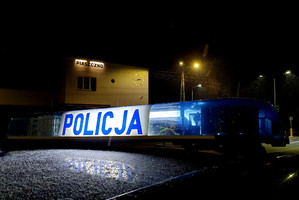 Radiowóz policyjny na tle budynku z napisem "Piaseczno"