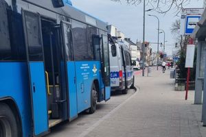 kontrolowany autobus koloru niebieskiego a przed nim stoi radiowóz policyjny