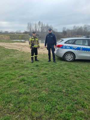 policjant oraz strażak obok radiowozu