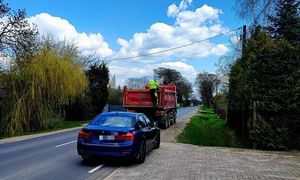 nieoznakowany radiowóz z wyświetlonym na tablicy napisem &quot;Policja&quot; oraz stojący przed nim samochód ciężarowy