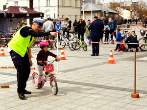 policjant wydziału ruchu drogowego wraz z dzieckiem na rowerze w trakcie pikniku rodzinnego