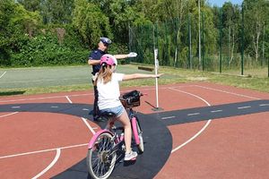 policjant kierujący ruchem i uczennica zdająca egzamin na kartę rowerową