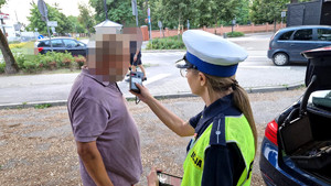 policjantka oraz mężczyzna w trakcie badania alkomatem