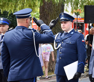 Na zdjęciu umundurowany policjant oddaje honor innemu umundurowanemu policjantowi.