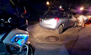 samochód marki skoda w trakcie wprowadzania na lawetę, w tle motocykl policyjny