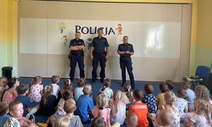 policjanci stoją przed dziećmi
