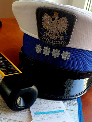 wydruk z badania, bloczek mandatowy i czapka policjanta wydziału ruchu drogowego