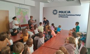 policjantka prowadząca spotkanie, dzieci siedzą przed nią