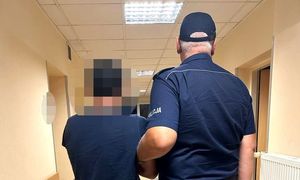 zatrzymany mężczyzna w asyście umundurowanego policjanta