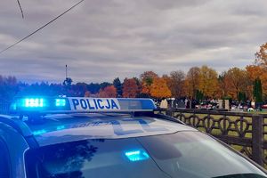 radiowóz policyjny, w tle cmentarz