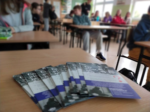 zdjęcie ze spotkania, ulotki, w tle młodzież