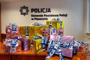 prezenty na tle napisu Komenda Powiatowa Policji w Piasecznie