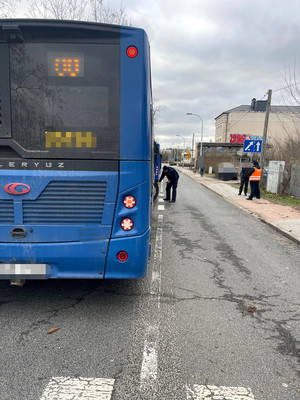 policjant kontrolujący stan techniczny niebieskiego autobusu