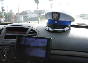 czapka policjanta wydziału ruchu drogowego oraz radiowóz